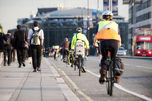 City workers walking and cycling over Waterloo Bridge at the end of the working day. Crash zoom effect done in camera.