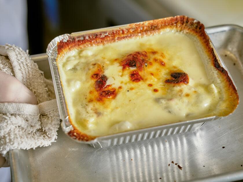 A rectangular foil pan holds creamy ravioli 