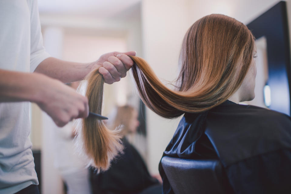 A person brushing a client's long hair