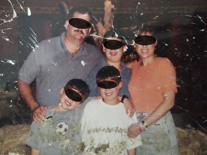 The family photo is seen with their faces redacted to protect their privacy