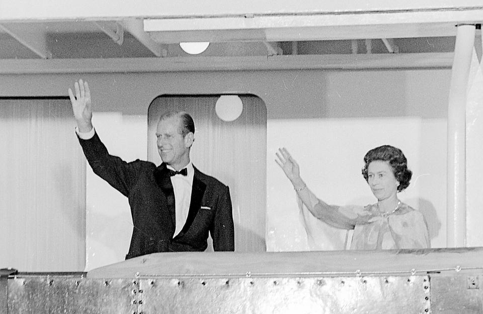Prince Philip and Queen Elizabeth II wave to an assembled crowd during a visit to Newport, Rhode Island, in 1976.
