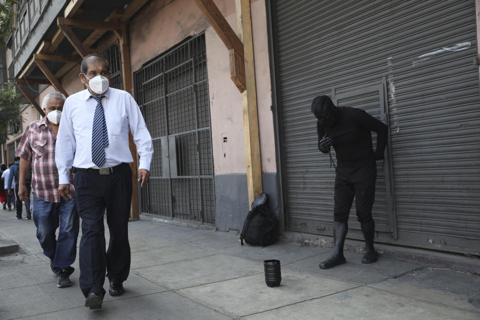 A street artist performs near Congress where Francisco Sagasti will arrive to be sworn-in as the new, interim president in Lima, Peru, Tuesday, Nov. 17, 2020. Sagasti's appointment marks a tumultuous week in which thousands took to the streets outraged by Congress' decision to oust popular ex-President Martín Vizcarra. (AP Photo/Rodrigo Abd)