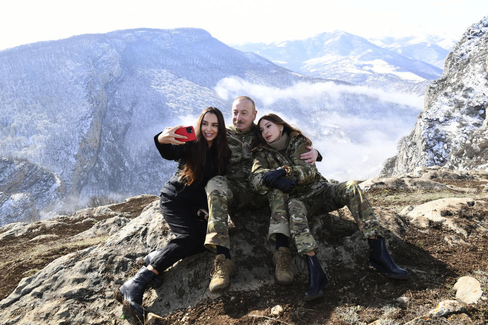 This photo provided by Azerbaijan's Presidential Press Office on Saturday, March 20, 2021, Azerbaijani President Ilham Aliyev, his wife and Azerbaijan's Vice President Mehriban Aliyeva, right, and his daughter Leyla Aliyeva pose for a selfie while celebrating Novruz Bayramı, a traditional holiday which celebrates the New Year and the coming of Spring in Shusha, Azerbaijan. Aliyev marked the Nowruz holiday by lighting a ceremonial fire outside Shusha, a culturally revered city that Azerbaijan took from Armenian forces in last autumn's war. Shusha, a center of Azeri culture for centuries, came under Armenian control in 1992 in fighting over the separatist Nagorno-Karabakh region. (Vugar Amrullaev, Azerbaijani Presidential Press Office via AP)