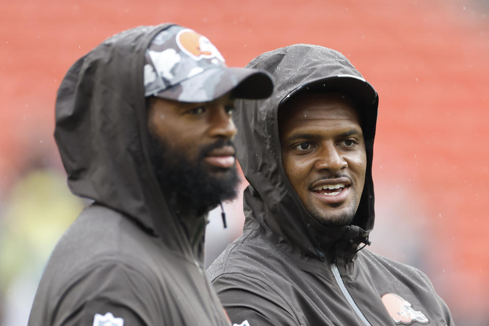 Cleveland Browns quarterbacks Deshaun Watson, right, and Jacoby Brissett talk on the field as they warm up before an NFL preseason football game against the Philadelphia Eagles in Cleveland, Sunday, Aug. 21, 2022. (AP Photo/Ron Schwane)
