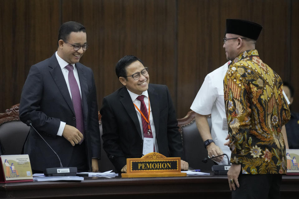 Losing presidential candidate Anies Baswedan, left, and his running mate Muhaimin Iskandar, center, shares a light moment with the Chairman of the General Election Commission Hasyim Asyari, right, prior to the first hearing of their legal challenge to the Feb. 14 presidential election alleging widespread fraud, at the Constitutional Court in Jakarta, Indonesia, Wednesday, March 27, 2024. Defense Minister Prabowo Subianto, who chose the son of the popular outgoing President Joko Widodo as his running mate, won the election by 58.6% of the votes, according to final results released by the Election Commission. (AP Photo/Dita Alangkara)