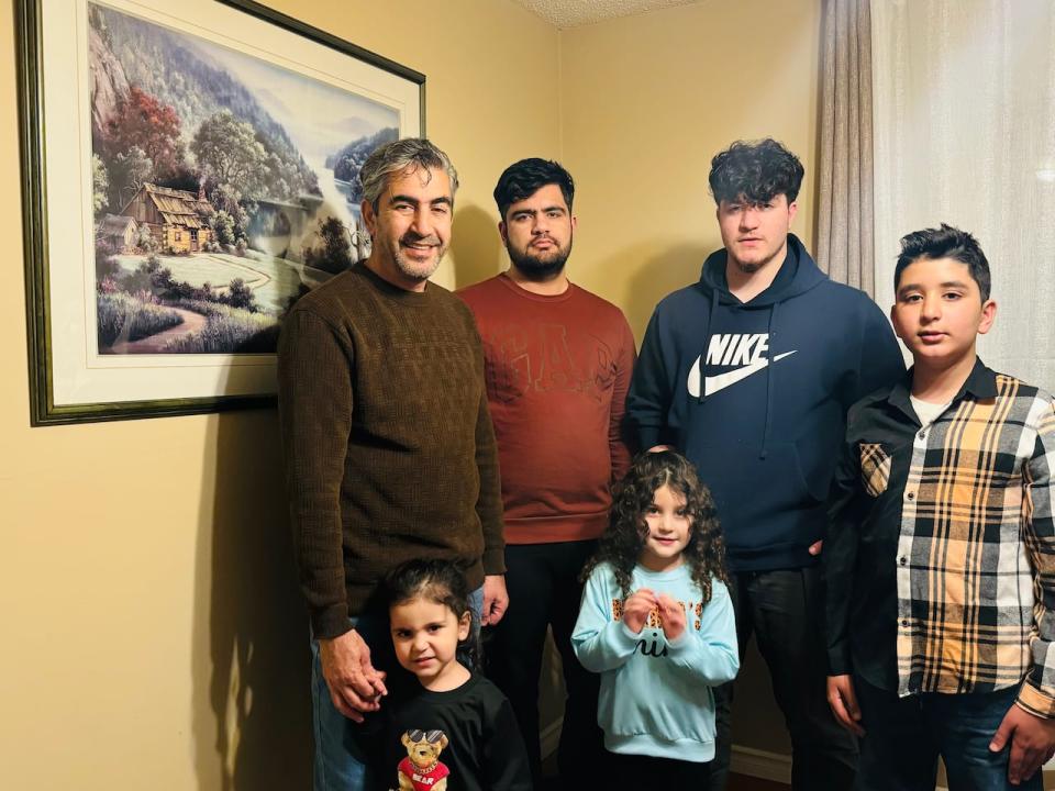 Wali Mohammad Dawari with his three sons and two daughters in the living room of their Calgary home. 