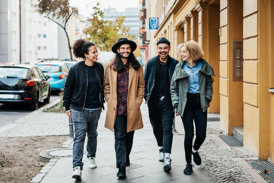 A stylish group of friends on chatting while making their way to a bar together for some drinks.