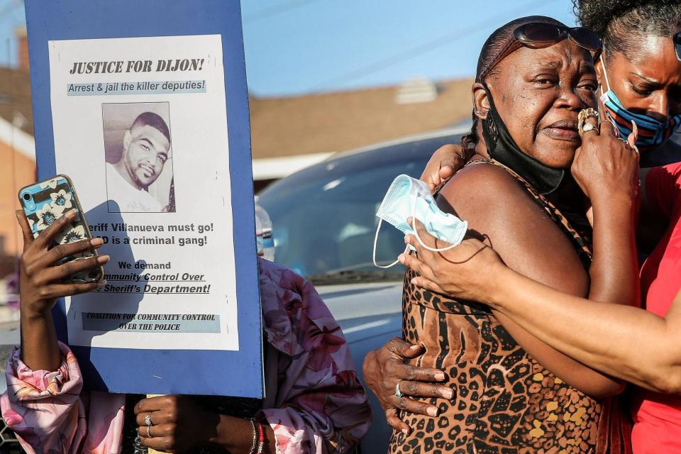 Debra Ray, aunt of Dijon Kizzee, is embraced after speaking near a makeshift memorial where Dijon Kizzee, a 29-year-old Black man, was shot dead by Los Angeles Sheriff's deputies: Getty Images