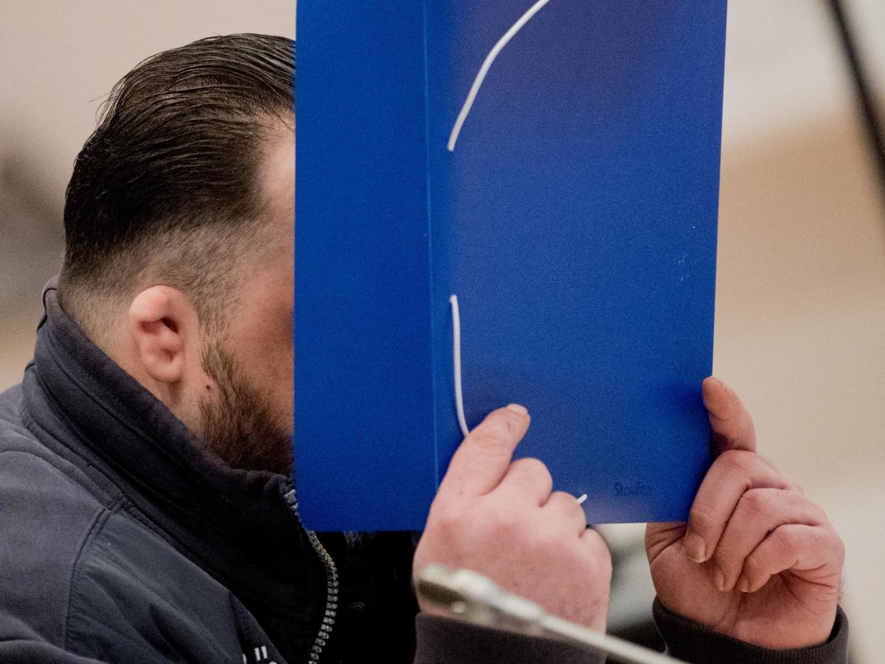 Niels Hoegel covers his face as a he arrives for his trial at a court in Oldenburg, Germany: Reuters