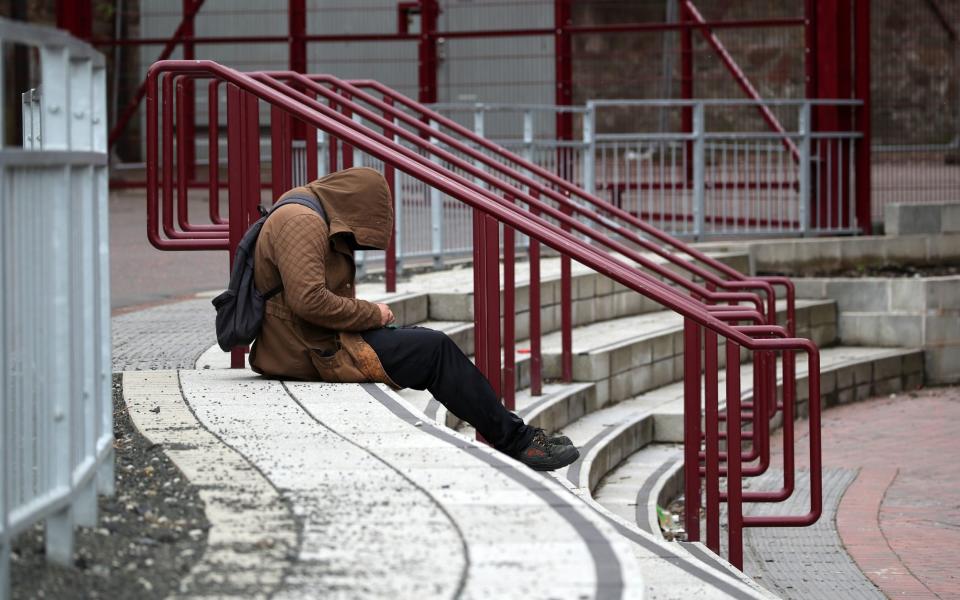 A man sits outside of Tynecastle Park, home of Heart of Midlothian - PA