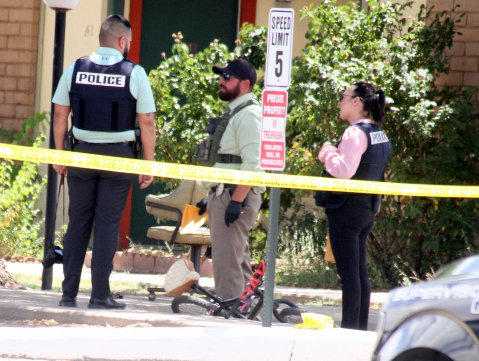 Deming police investigators meet next to a BMX-style bicycle at Monday's crime scene at the Deming Manor Apartments.
(Photo: Bill Armendariz - Headlight Photo)