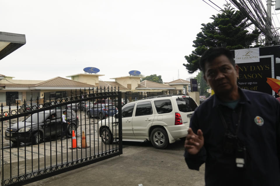 A security person tries to block a photographer from taking pictures outside the Lake Hotel in Tagaytay city, south of Manila, Philippines on Thursday, July 11, 2024. Two Australian nationals and a Filipina companion were killed at the Lake Hotel and police efforts were underway to identify and track down suspects, officials said. (AP Photo/Aaron Favila)