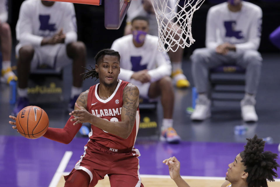 Alabama guard John Petty Jr. passes the ball as LSU forward Trendon Watford defends during the first half of an NCAA college basketball game in Baton Rouge, La., Tuesday, Jan. 19, 2021. (AP Photo/Brett Duke)