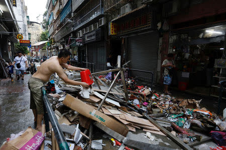 A man cleans his store after Typhoon Hato hit in Macau, China August 24, 2017. REUTERS/Tyrone Siu