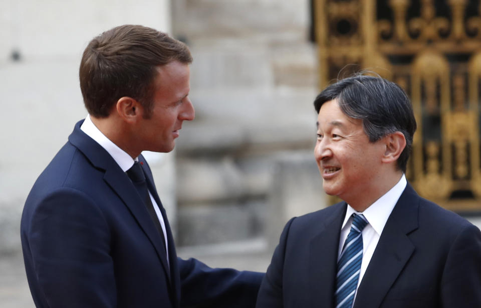 FILE - In this Sept. 12, 2018, file photo, Japan's Crown Prince Naruhito, right, is greeted by French President Emmanuel Macron before a meeting at the Chateau de Versailles, west of Paris. On May 1, 2019, when Crown Prince Naruhito becomes, by official Japanese count, the nation’s 126th person to sit on the Chrysanthemum Throne since 660 B.C., he will be ceremonially armed with the glittering, ancient imperial regalia of sword, mirror and jewel. (AP Photo/Christophe Ena, File)