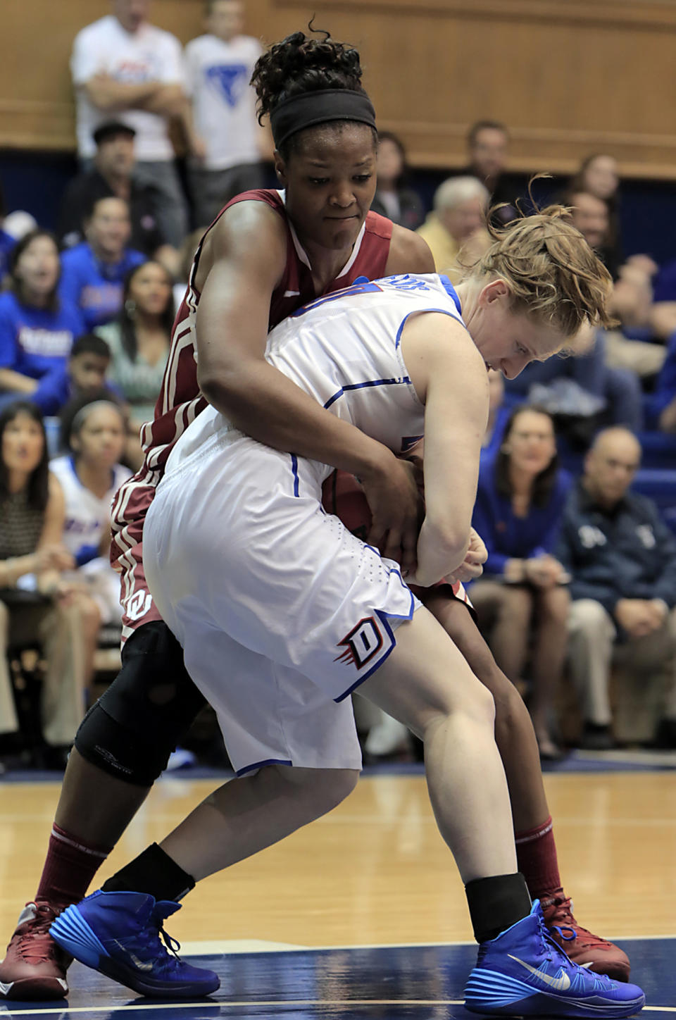 Oklahoma's Kaylon Williams, background, ties-up DePaul's Kelsey Reynolds during the first half of their first-round game in the NCAA basketball tournament in Durham, N.C., Saturday, March 22, 2014. (AP Photo/Ted Richardson)