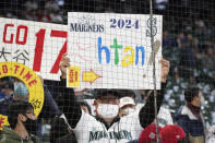 A Seattle Mariners fan holds a sign encouraging the Mariners to sign Los Angeles Angels' Shohei Ohtani in 2024 before a baseball game between the two teams, Sunday, Oct. 3, 2021, in Seattle. (AP Photo/Ted S. Warren)