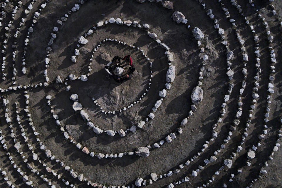 A group of Brazilian tourists hold hands standing in a circle at the heart of a stone labyrinth in the Pueblo Encanto spiritual theme park in Capilla del Monte, Argentina, Wednesday, July 19, 2023. In the pope’s homeland of Argentina, Catholics have been renouncing the faith and joining the growing ranks of the religiously unaffiliated. Commonly known as the “nones,” they describe themselves as atheists, agnostics, spiritual but not religious, or simply: “nothing in particular.” (AP Photo/Natacha Pisarenko)