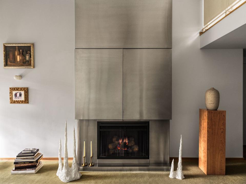 full on view of the fireplace clad from mantel to ceiling in stainless steel