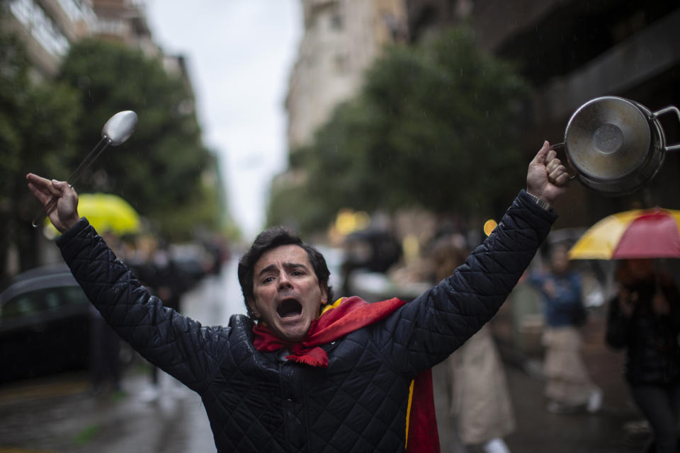A man with a Spanish flag wrapped on his shoulders shouts slogans during a protest against the Spanish government amid the lockdown to prevent the spread of coronavirus in Madrid, Spain, Tuesday, May 12, 2020. Roughly half of 47 million Spaniards are stepping into a softer version of the country's coronavirus strict confinement and are beginning to socialize, today on second day, shop in small establishments and enjoy a meal or a coffee in restaurants and bars with outdoor seating. The hard-hit region around the Spanish capital, Madrid, and Barcelona, in the northeastern Catalonia region, are among those territories that remain under stricter measures. (AP Photo/Manu Fernandez)