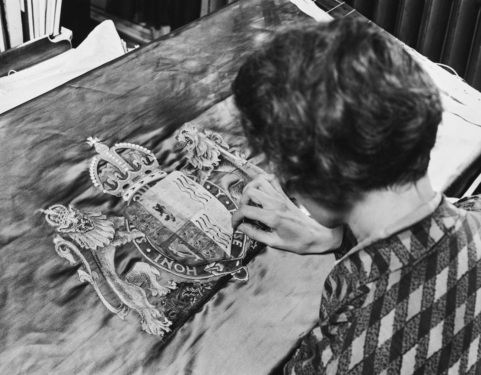 A woman sews Queen Elizabeth's crest for the Chair of Recognition, for the coronation ceremony of George VI and Queen Elizabeth, on March 18, 1937.<span class="copyright">Fox Photos/Hulton Archive/Getty Images</span>