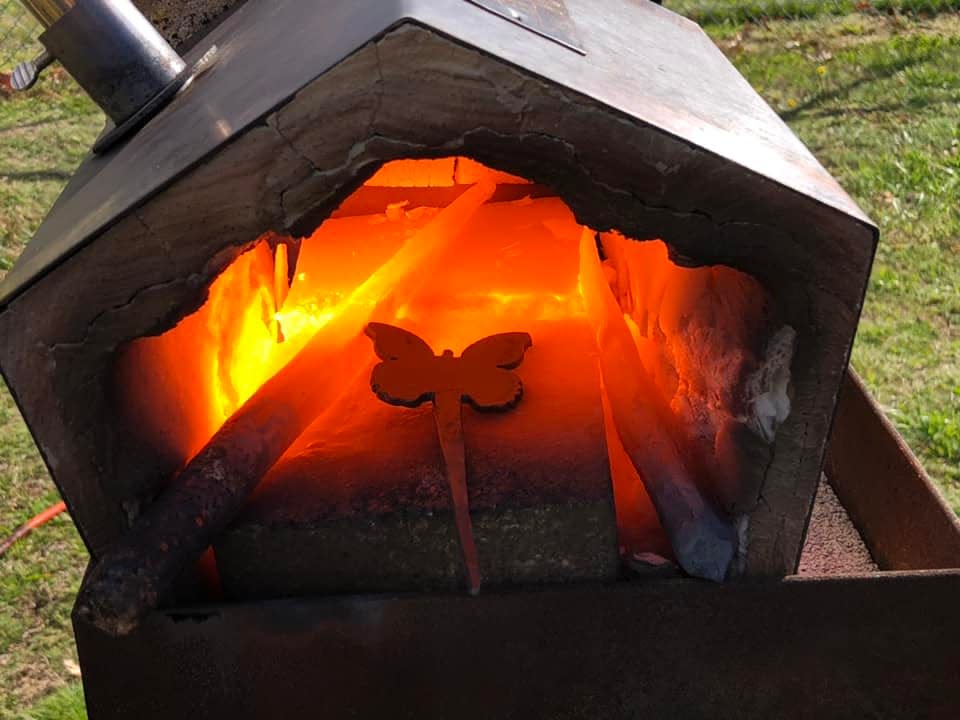 A butterfly hook heats up in a 1500-degree furnace before being forged by The Social Butterfly Kristi K. Higgins and Thomas Goodemoot with Christ Centered Ironworks at the Central Virginia Blacksmith Guild Hammer-In in Chesterfield on March 11, 2023.
