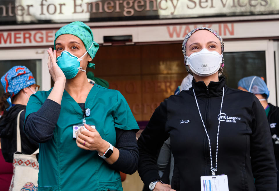 Medical staff stand outside NYU Langone Health hospital as people applaud to show their gratitude to essential workers on the frontlines of the COVID-19 pandemic in 2020.