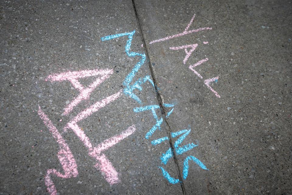 A chalk drawing reads "Y'all means all" during a protest in support of transgender-rights as Matt Walsh speaks at an event hosted by the Young America's Foundation, Wednesday, April 19, 2023, outside the Iowa Memorial Union on the University of Iowa campus in Iowa City, Iowa.