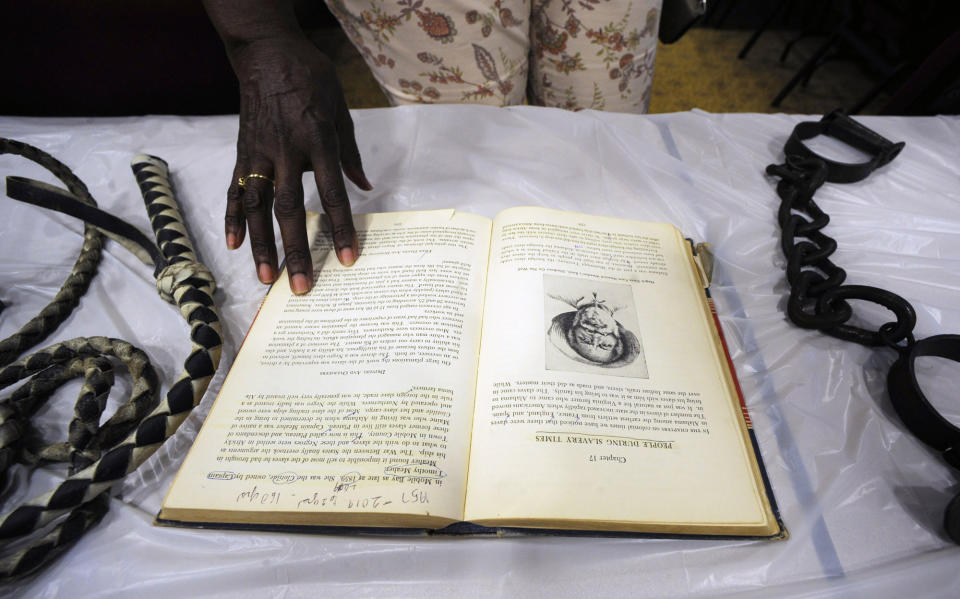 FILE - Barbara Martin looks at a display about slavery in Mobile, Ala., on Monday, Aug. 26, 2019. Republican Tommy Tuberville told people Saturday, Oct. 8, 2022, at an election rally in Nevada that Democrats support reparations for the descendants of enslaved people because “they think the people that do the crime are owed that.” His remarks cut deeply for some, especially in and around Africatown, a community in Mobile, Alabama, that was founded by descendants of Africans smuggled in 1860 to the United States aboard a schooner called the Clotilda. (AP Photo/Jay Reeves, File)