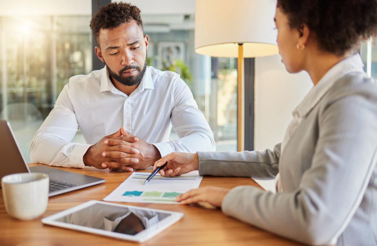 Accountant consulting an entrepreneur about company financial performance in an office using statistics. Finance advisor in a meeting having a business growth strategy discussion with businessman