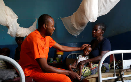 Dr. Elvis Badinaga (L) examines Kaba Bitika Marie, 19 months, an internally displaced and severely acute malnourished child as her grandmother Tchitita Mutombo looks on at the Presbyterian hospital in Dibindi zone of Mbuji Mayi in Kasai Oriental Province in the Democratic Republic of Congo, March 16, 2018. Picture taken March 16, 2018. REUTERS/Thomas Mukoya