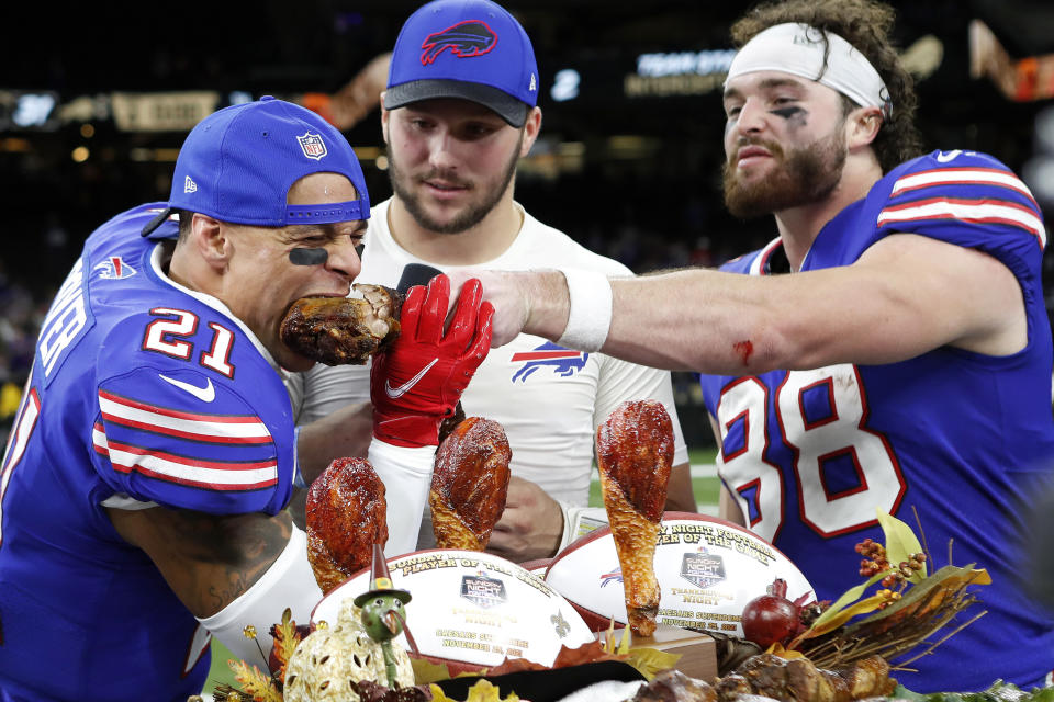 FIEL - Buffalo Bills wide receiver Stefon Diggs (14), safety Jordan Poyer (21), quarterback Josh Allen (17), and tight end Dawson Knox (88) eat a Thanksgiving turkey after an NFL football game against the New Orleans Saints, Thursday, Nov. 25, 2021, in New Orleans. From awarding victory turkey legs to the star players to being the voice on the NFL's biggest Thanksgiving Day games for years, John Madden was synonymous with the holiday he so adored. The NFL is making that a lasting tribute by honoring the late broadcaster by launching The Annual John Madden Thanksgiving Celebration to begin on the first Thanksgiving following his death last December. (AP Photo/Tyler Kaufman, File)