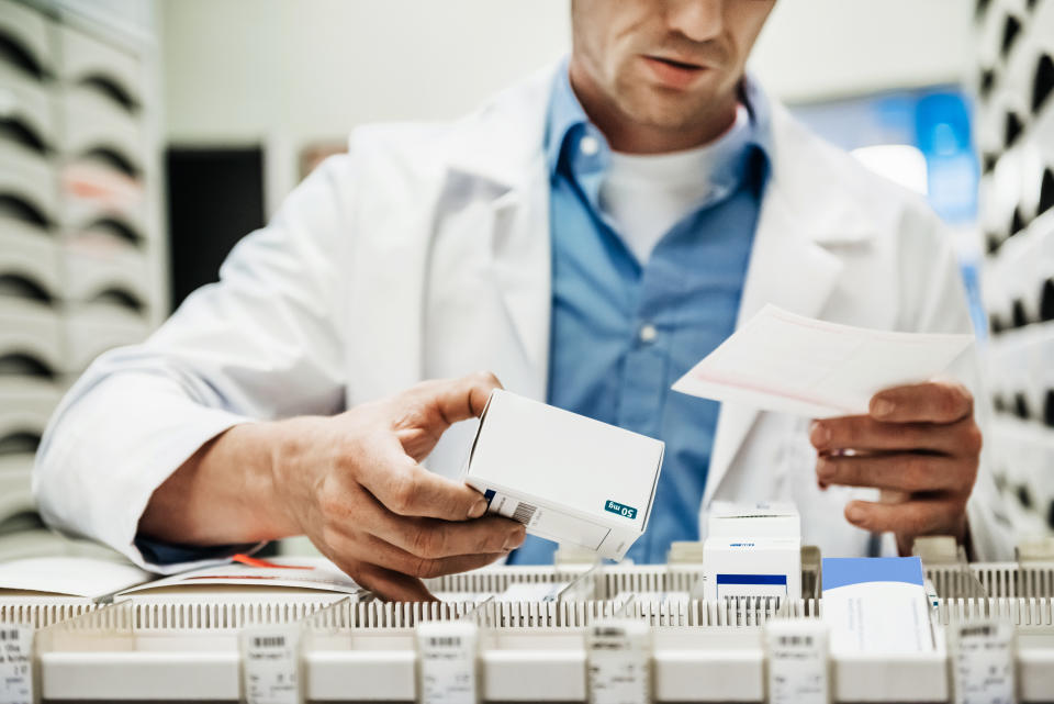 Un empleado de una farmacia busca medicamentos. Foto: Getty.