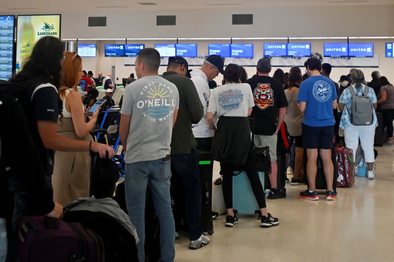 Passengers try to rebook their tickets from cancelled United Airlines flights in San Juan