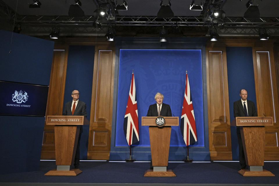 Britain's Prime Minister Boris Johnson, center, speaks during a media briefing on coronavirus in Downing Street, London, Monday, July 5, 2021. Johnson says people in England will no longer be required by law to wear face masks in indoor public spaces and to keep at least 1 meter (3 feet) apart as soon as later this month. Johnson on Monday confirmed plans to reopen society despite rising coronavirus cases. (Daniel Leal-Olivas/Pool Photo via AP)