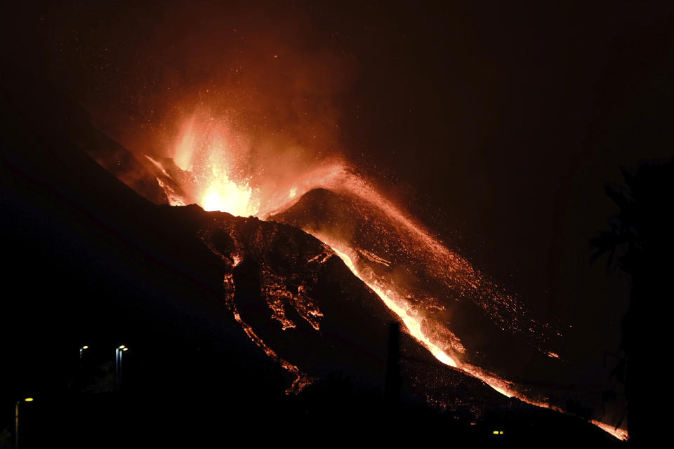 A volcano continues to spew out lava on the Canary island of La Palma, Spain in the early hours of Sunday, Oct. 10, 2021. A new river of lava has belched out from the La Palma volcano, spreading more destruction on the Atlantic Ocean island where molten rock streams have already engulfed over 1,000 buildings. The partial collapse of the volcanic cone has sent a new lava stream heading toward the western shore of the island. (AP Photo/Daniel Roca)