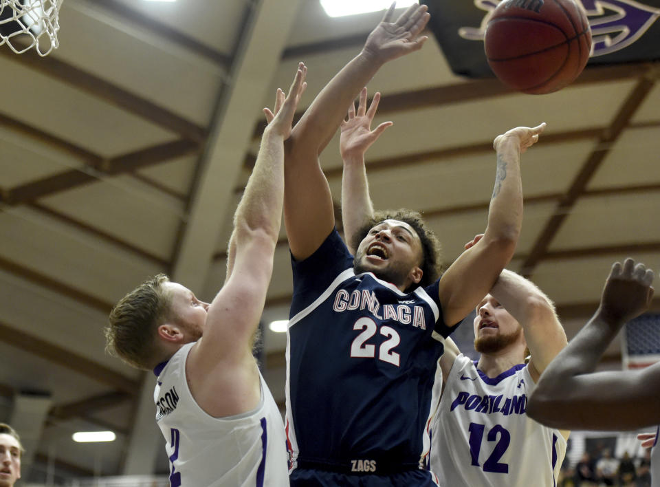 Gonzaga forward Anton Watson, center goes after a rebound with Portland guard Tyler Robertson, left, and forward Kristian Sjolund, right, during the first half of an NCAA college basketball game in Portland, Ore., Saturday, Jan. 28, 2023. (AP Photo/Steve Dykes)