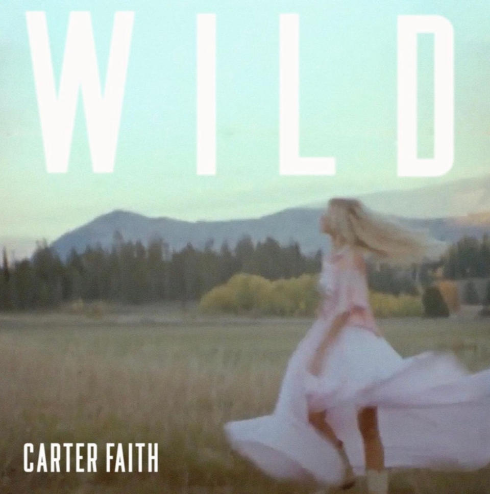 Single cover for "Wild" by Carter Faith, showing Carter walking in a grassy field