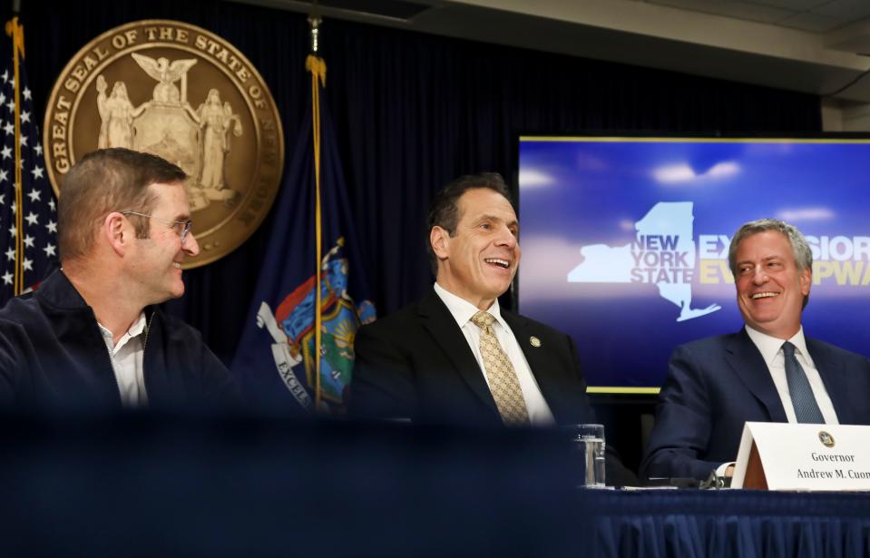 John Schoettler, Amazon vice president for real estate and facilities, left, joins New York Gov. Andrew Cuomo, center, and New York City Mayor Bill de Blasio during a news conference Tuesday Nov. 13, 2018, in New York.  (AP Photo/Bebeto Matthews)