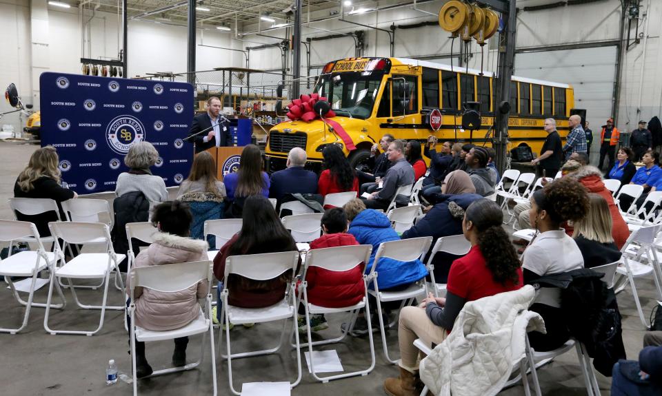 People listen to speakers at the reveal of two new all-electric school buses Friday, Jan. 27, 2023, at the South Bend school district’s bus facility on Bendix Drive in South Bend.