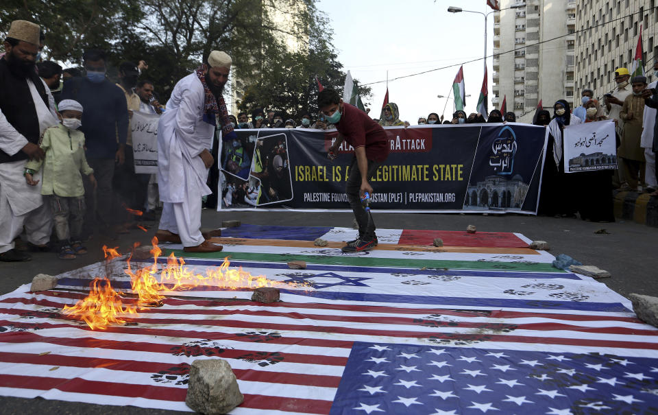 Members of a civil society group burn representations of Israeli, U.S. and Indian flags during a demonstration in support of Palestinians during the latest round of violence in Jerusalem, in Karachi, Pakistan, Tuesday, May 11, 2021. (AP Photo/Fareed Khan)