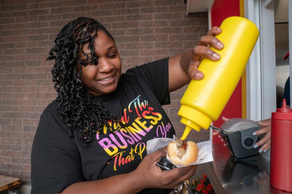 Sabrina Bethel, 40, of Southfield puts mustard on her hot dog outside of the Madison Heights Home Depot on 12 Mile on Monday, Sept. 11, 2023.