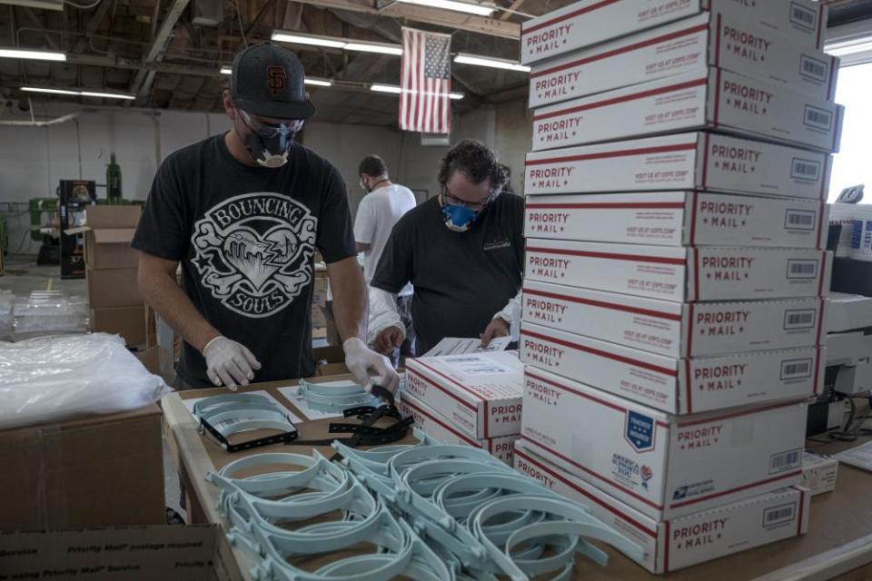 Workers pack orders for face shields at Mask & Shield, a division of Monster City Studios, in Fresno, California, in May.