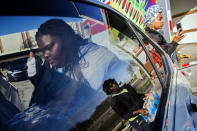 FILE - In this April 22, 2019 file photo, Ja'Kayla Norris, front left, loads vehicles with free bottled water alongside other volunteers in Flint, Mich. A judge granted preliminary approval Thursday, Jan. 21, 2021, to a $641 million deal that would benefit Flint residents who were harmed by lead-contaminated water. The settlement includes $600 million from the state of Michigan, although Flint, an area hospital and an engineering firm are also part of the agreement. (Jake May/The Flint Journal via AP)