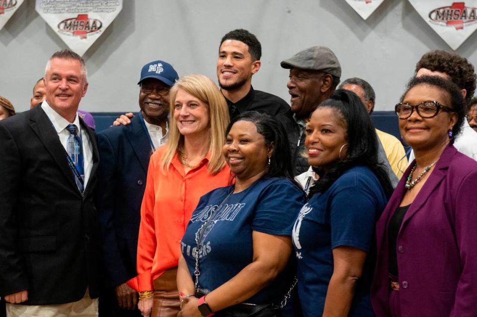 NBA star Devin Booker poses for a photo with Moss Point administrators and teachers during a ceremony for the retirement of Booker’s high school jersey at Moss Point High School in Moss Point on Saturday, Dec. 10, 2022.