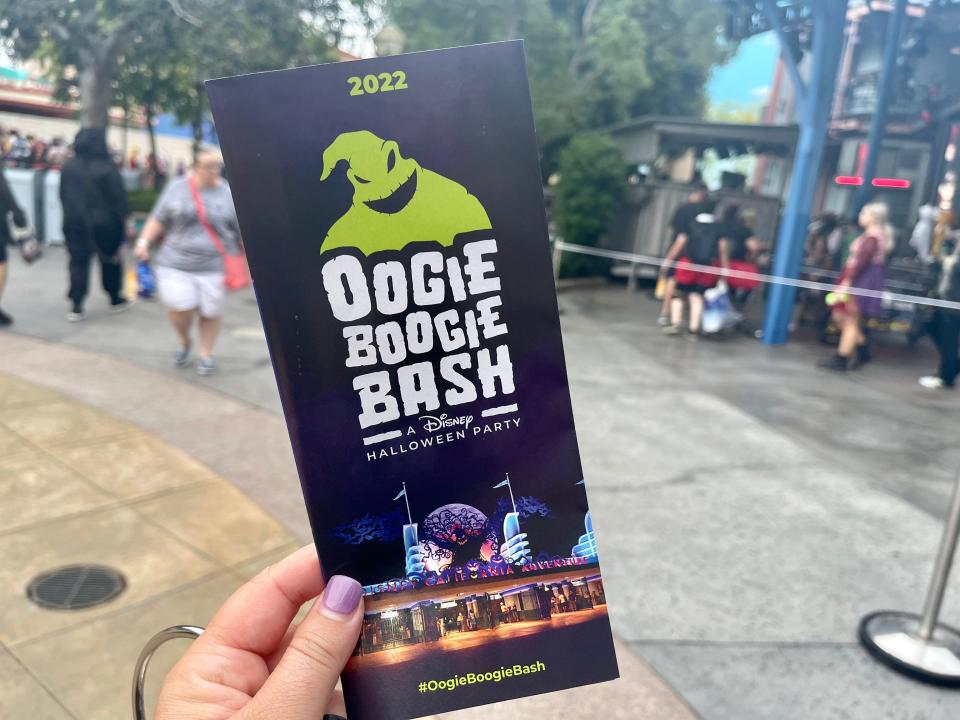 hand holding oogie boogie bash event guide