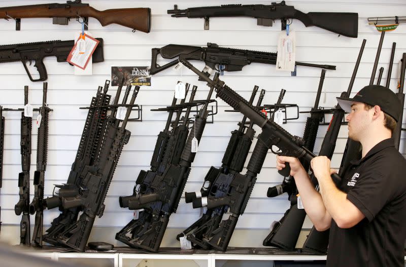 FILE PHOTO: Salesman Ryan Martinez clears the chamber of an AR-15 at the "Ready Gunner" gun store In Provo