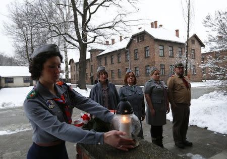 Members of Polish Scouting Association from Canada and U.K. place a lit candle at block 15 in the former Nazi German concentration and extermination camp Auschwitz in Oswiecim January 26, 2015. REUTERS/Laszlo Balogh