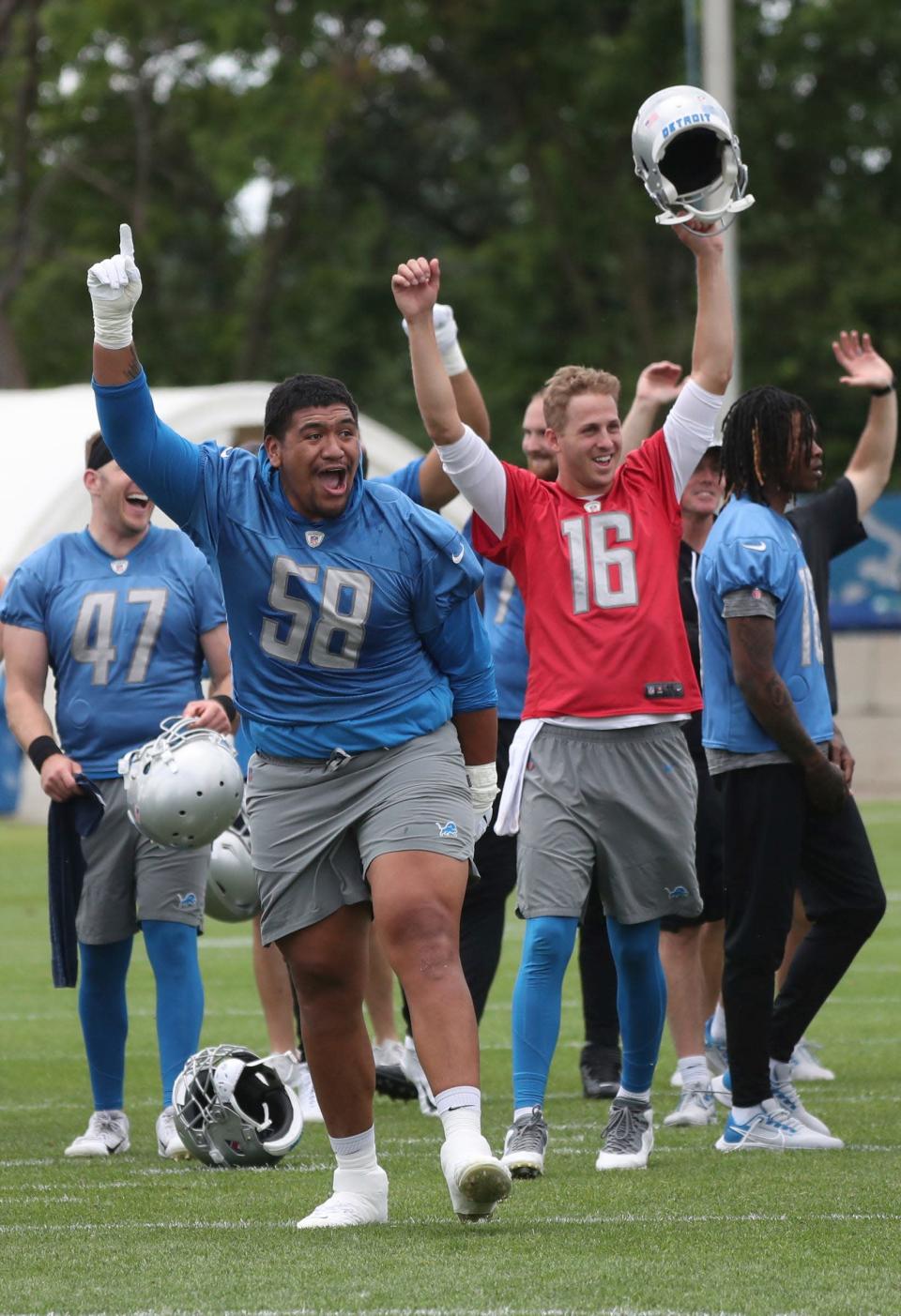 Lions offensive lineman Penei Sewell and quarterback Jared Goff react after offensive lineman Kevin Jarvis successfully fielded a punt during a drill after practice during minicamp on Thursday, June 9, 2022, in Allen Park.