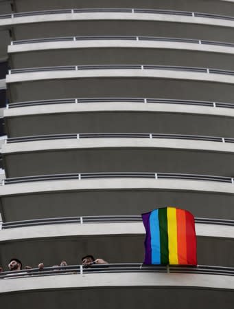 A rainbow flag waves at an apartment building during the Gay Pride parade along a Central Avenue, in San Jose